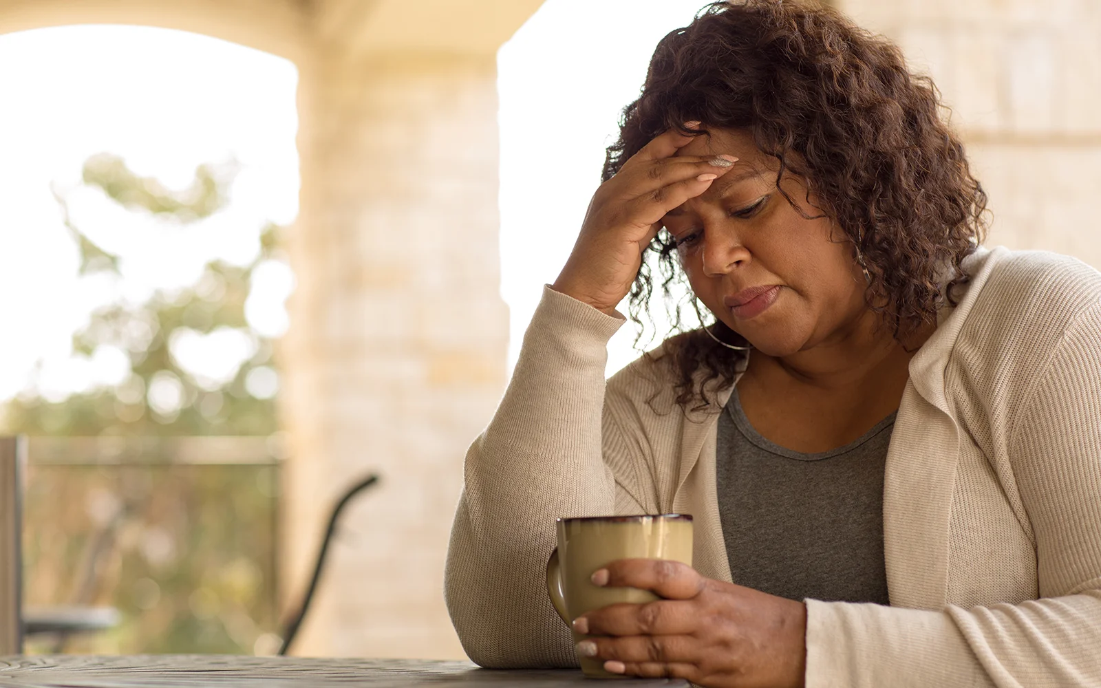 Woman holding her stomach and feeling uncomfortably bloated after a meal